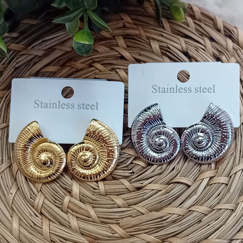 Brincos em forma de Concha/Espiral Cor dourada Aço inoxidável. Disponível também em Prateado A beleza está nos detalhes; complete seu look com um toque especial. Seja você mesma, e brilhe intensamente!