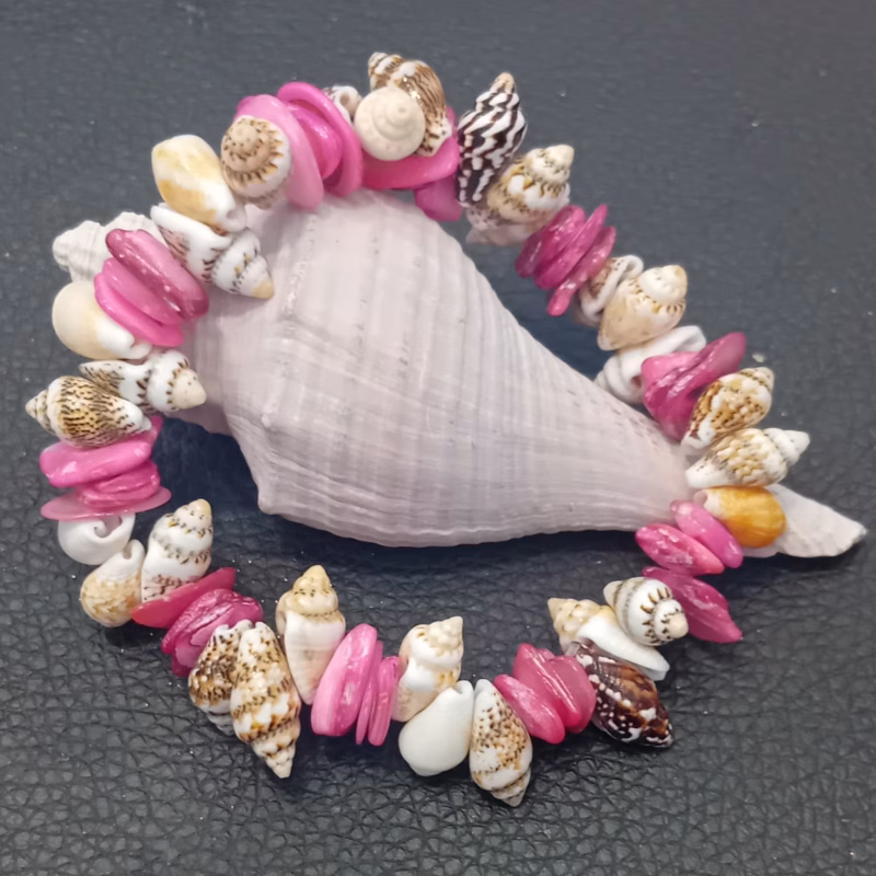 BIJUTERIA – Pulseira Boho #04 Artezanal Estilo Design de estilo boémio-chic, ideal para férias na praia Cor: Fúcsia e Branco Material Conchas de Búzios, Madrepérola e Conchas em formato de cone Limitado ao stock existente