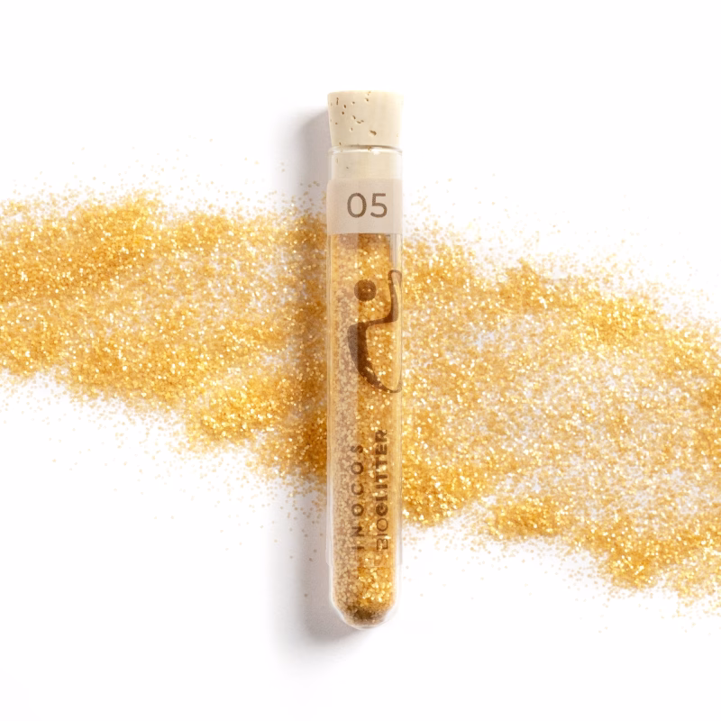 INOCOS - BIOGLITTER 05 Dourado Glitter Biodegradável REF. 87.01.043 Apresentamos-te o Bioglitter INOCOS 05 Dourado 0.4mm. Características: - Glitter biodegradável e ecológico. - Formulação à base de plantas. - Sem plástico na sua composição. - Seguro para aplicação em unhas e pele. - Textura fina e aderência uniforme. - Brilho intenso, duradouro e versátil. - Disponível em 12 variedades diferentes.