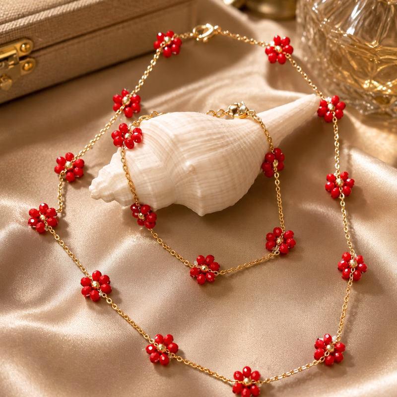 Bijuteria - Conjunto Fio e Pulseira Floral Vermelho Este delicado conjunto de elos dourados apresenta um encantador motivo floral composto por pequenas contas vermelhas em formato de margarida. Pode ser vendido em separado Fio 7€ Pulseira 5€ Limitado ao Stock existente