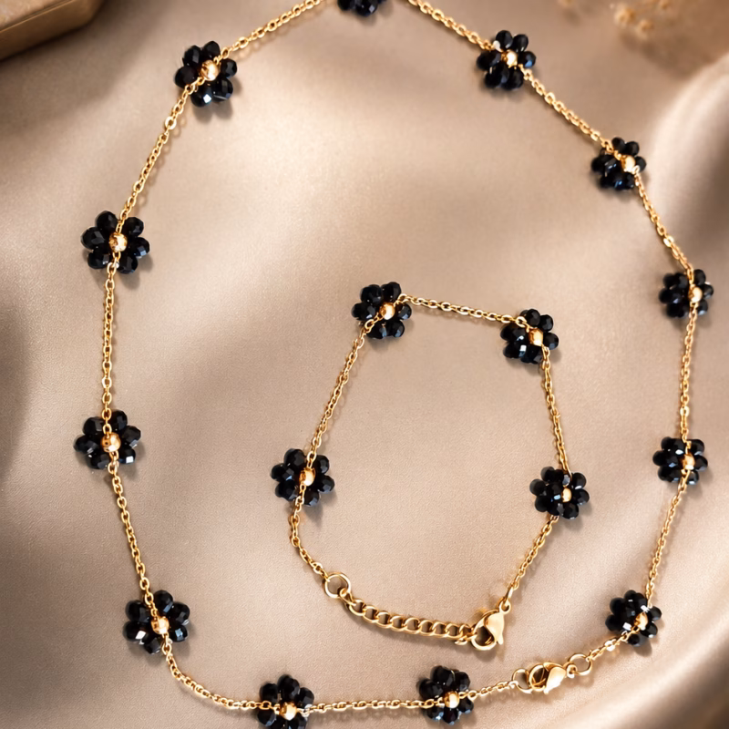 Bijuteria – Conjunto Fio e Pulseira Floral Preto Este delicado conjunto de elos dourados apresenta um encantador motivo floral composto por pequenas contas Preto em formato de margarida. Fio 7€ Pulseira 5€ Limitado ao Stock existente